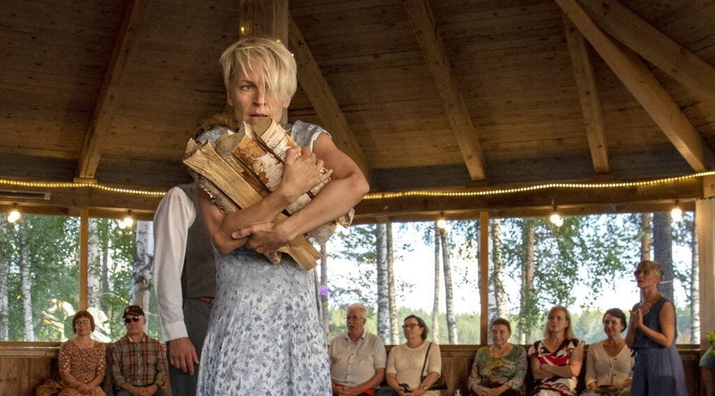 Tanssiesitys, naisella klapeja sylissä.