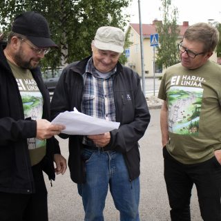 Kolme miestä torilla.