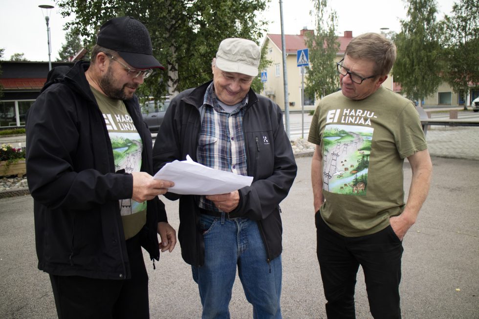 Kolme miestä torilla.