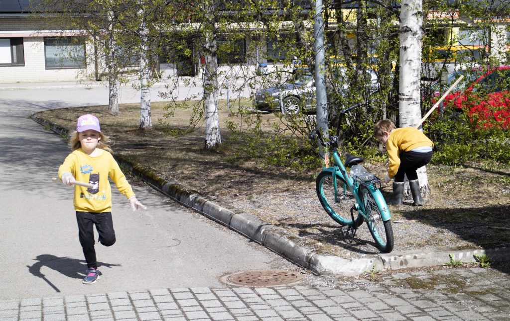 Roskajahti, kaksi lasta keräämässä roskia torin laidalta.