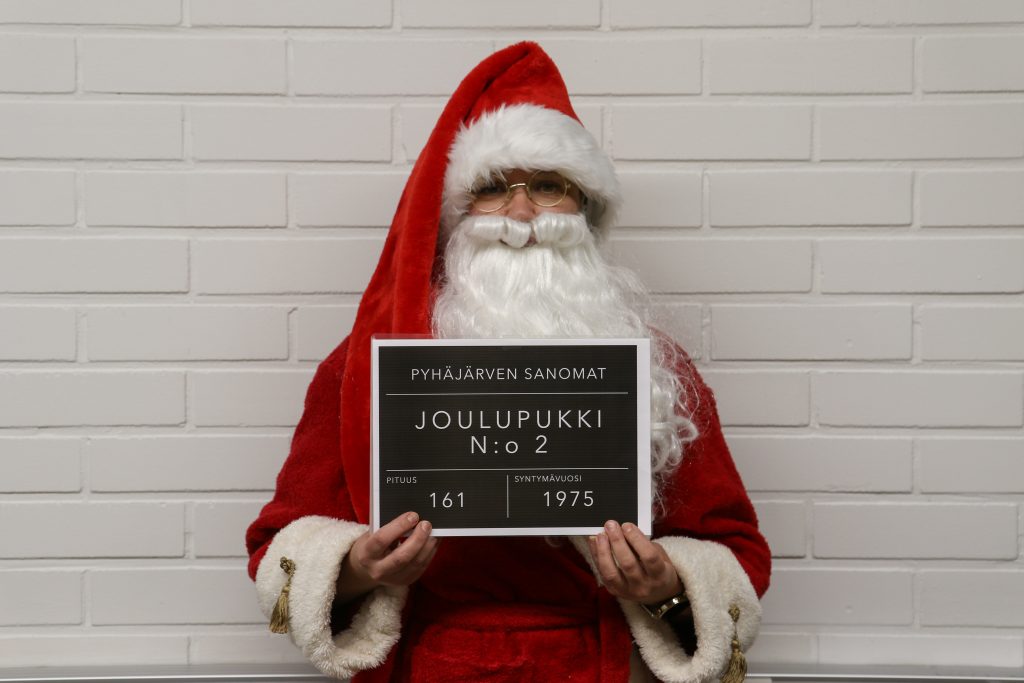 Kuvassa on henkilö, joka on naamioitunut joulupukin asuun. 