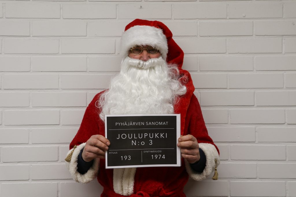 Kuvassa on henkilö, joka on naamioitunut joulupukin asuun. 