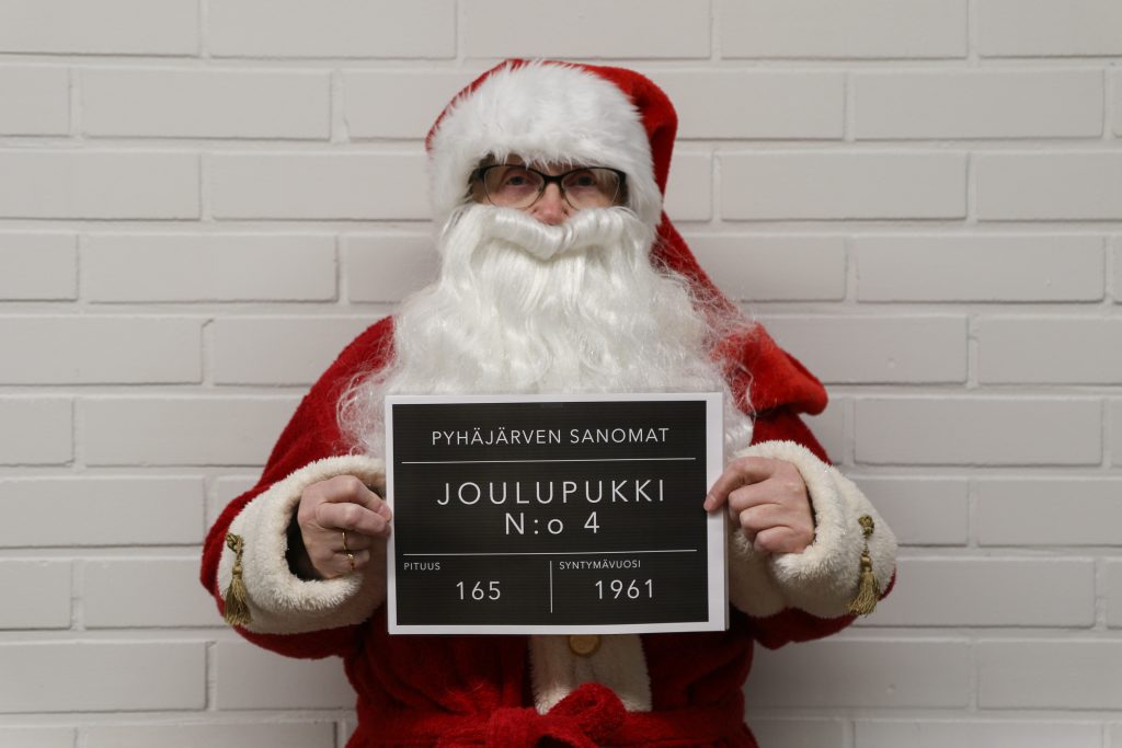 Kuvassa on henkilö, joka on naamioitunut joulupukin asuun. 