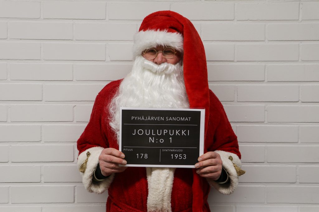 Kuvassa on henkilö, joka on naamioitunut joulupukin asuun. 